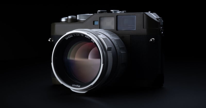 A close-up of a modern digital camera with a large lens, set against a black background. The camera features a metallic finish with various buttons and dials on the top. Reflections are visible on the lens surface.