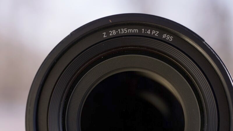 4 PZ ø95" on the rim. The lens is centered in the image with a blurred, light background.