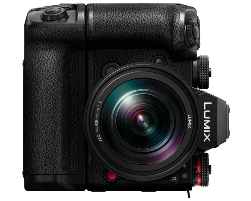 A black Panasonic Lumix mirrorless camera with a textured grip and a large lens attached. The lens displays light reflections. The camera has several buttons and dials, and the Lumix brand name is visible on the front.