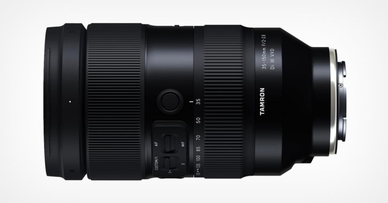 A black camera lens with a sleek design, displaying the Tamron logo and specifications: "35-150mm F/2-2.8 Di III VXD." The lens features manual controls and zoom markings on its surface, set against a light gray background.