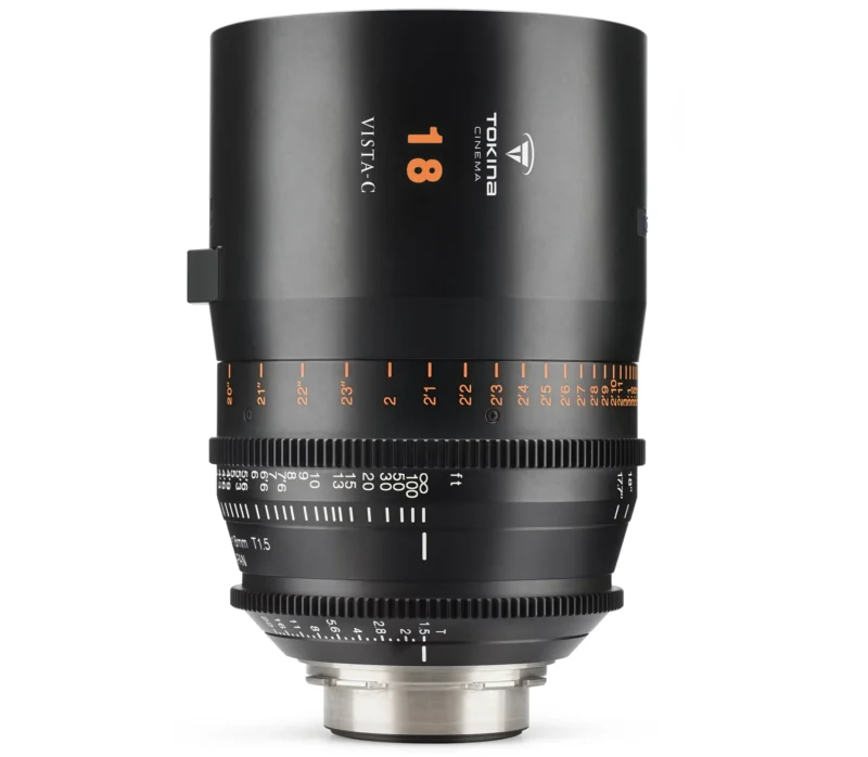 A Tokina Cinema Vista C 18mm T1.5 lens, featuring a smooth black finish with orange and white markings. It has a robust build with focus and aperture rings. The lens is standing upright on a white background.