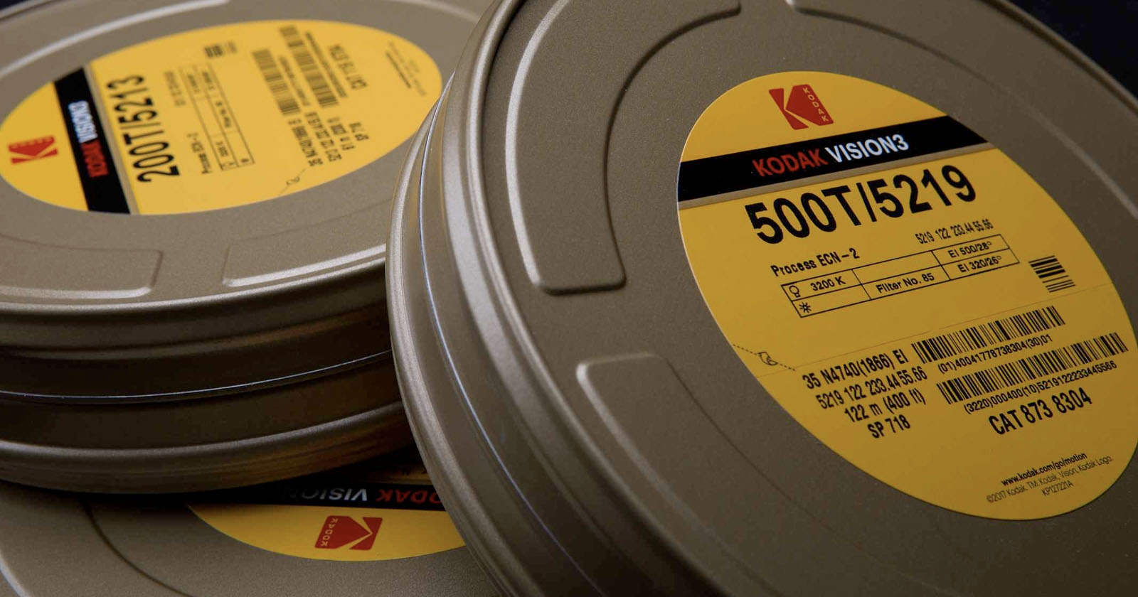 Close-up of Kodak film canisters stacked on each other. The top canister's label displays 