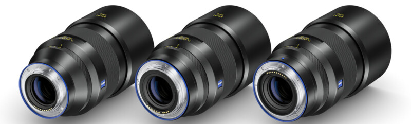 Three black camera lenses are aligned diagonally side by side against a white background. They feature blue accents around the lens mounts, and the brand logo is visible on each lens barrel.