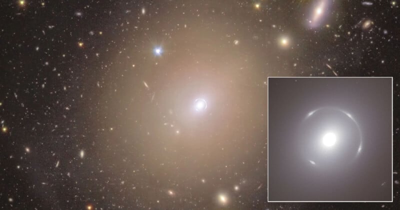 A nearly circular arc of light, known as an Einstein ring, surrounds a bright galaxy at the center of a star-filled sky. An inset shows a closer view of the ring and central galaxy, with other galaxies visible in the background.