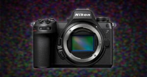 A Nikon Z series mirrorless camera, displaying the lens mount and sensor, set against a colorful, blurred background.