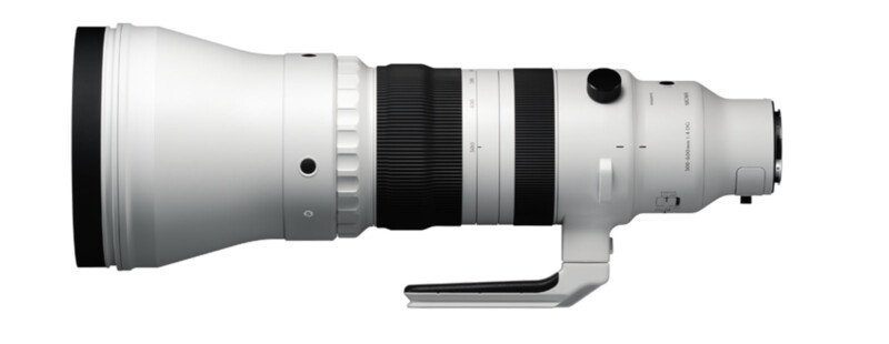 A large, white telephoto camera lens with a black grip section and mounting bracket. It features various adjustment rings and buttons, suited for professional photography, especially wildlife or sports. The lens is positioned horizontally.