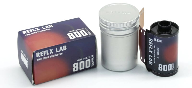 A box of REFLX LAB 35mm color negative film is shown alongside a silver film canister and a partially unrolled roll of film. The film is labeled for 800 ISO with 36 exposures.