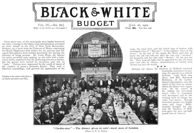 A historical black and white photo depicts a large group of men in suits sitting at banquet tables set with plates and glasses. A sign above them reads "Our Cats Meat Dinner." A grand organ is seen in the background.