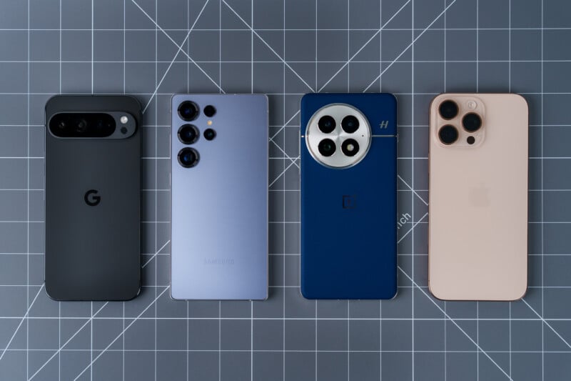 Four smartphones with different designs are placed on a grid-patterned surface. From left to right: a black phone with a "G" logo, a metallic gray phone with three rear cameras, a blue phone with four cameras, and a beige phone with three cameras.