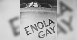 A man waves from the cockpit window of an airplane. The nose of the plane has the name "Enola Gay" painted in bold letters. The image is black and white, capturing a moment of historical significance.