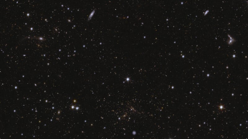 A vast starry sky filled with numerous bright stars and distant galaxies scattered across a dark background. Various star intensities create a sense of depth, presenting an expansive view of the Universe.