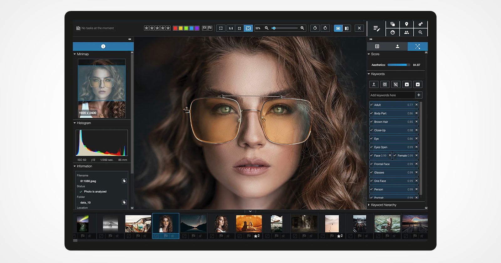 A photo editing software interface displaying an image of a woman with curly hair and large sunglasses. Various editing tools and options are visible, including layers, color adjustments, and a histogram. Thumbnails of other images are at the bottom.