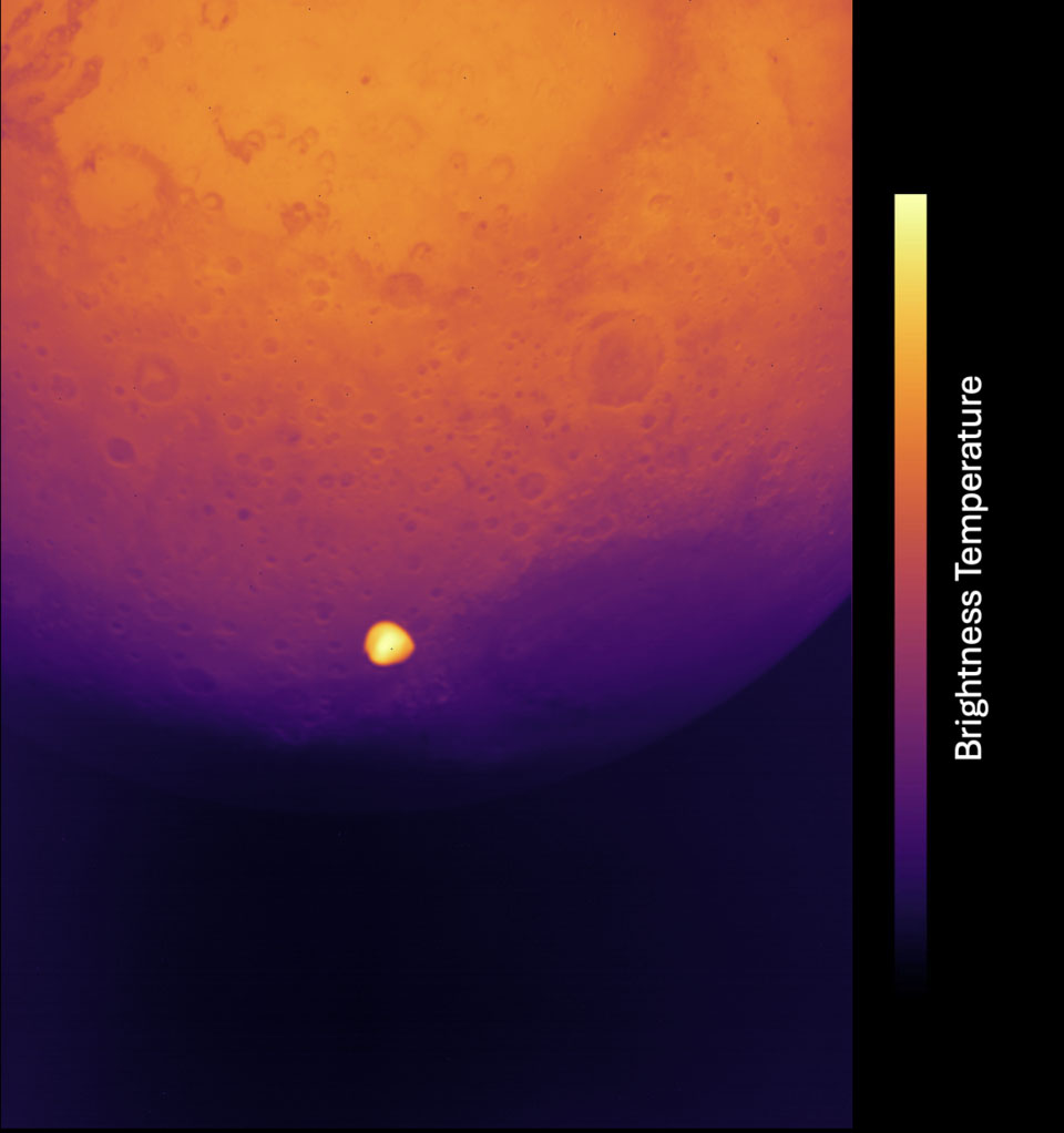 A heat map image of the Moon with a bright spot showing temperature variations. The gradient bar on the right side indicates brightness temperature from dark purple (cool) to bright yellow (warm).