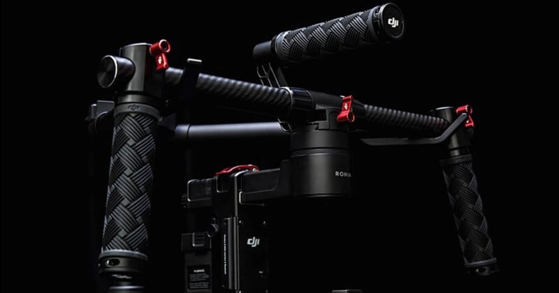 Close-up of a black DJI camera stabilizer featuring textured grips and red accents against a dark background.