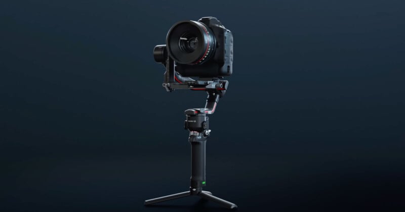 A professional DSLR camera mounted on a motorized gimbal stabilizer with a tripod base, set against a dark background.