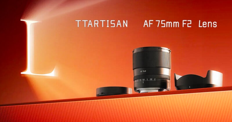 A camera lens is displayed on an orange surface with a lens cap and hood. The text reads "TTARTISAN AF 75mm F2 Lens" against an orange background with a large illuminated letter "L" on the left side.