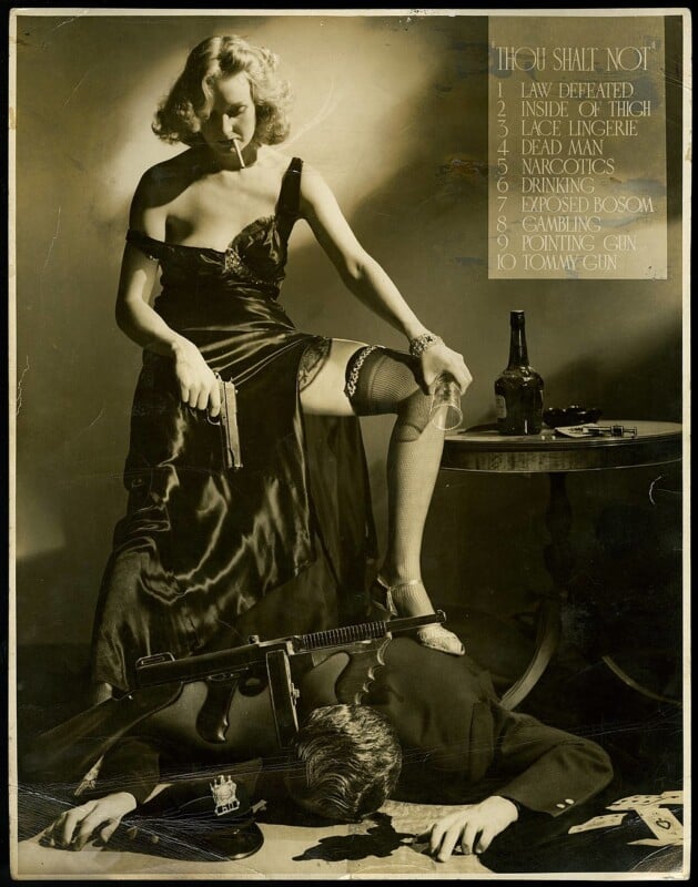 A woman in a black gown holds a gun and poses with one leg on a man's back. The man is lying face down with a gun by his side. A list titled "Thou Shalt Not" is visible on the right. The scene is dimly lit, with a bottle on a nearby table.