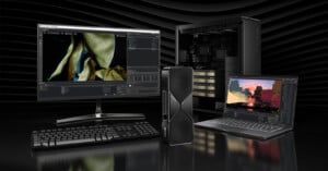 A desktop setup includes a monitor displaying graphics software, a keyboard, a tower PC, and a laptop displaying 3D rendering. The background is a dark, subtle wave pattern.