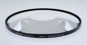 A close-up view of a Schneider-Kreuznach 138mm Spot 50 Close-Up lens filter. The filter is circular with a black rim displaying its specifications, and is placed on a neutral background.