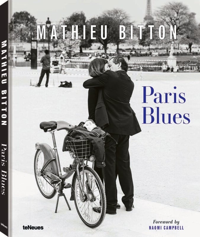 Book cover for "Paris Blues" by Mathieu Bitton shows a black-and-white photo of a couple embracing near a bicycle in Paris, with the Eiffel Tower blurred in the background.