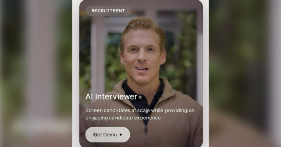 A man with short, light brown hair and a brown sweater speaks in a video. The text reads: "RECRUITMENT AI Interviewer Screen candidates at scale while providing an engaging candidate experience. Get Demo." The background is blurred greenery.