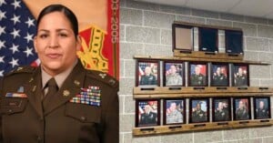 A woman in military uniform stands in front of U.S. flags; next to her is a wall display of framed military portraits in two rows, with three empty frames above them.