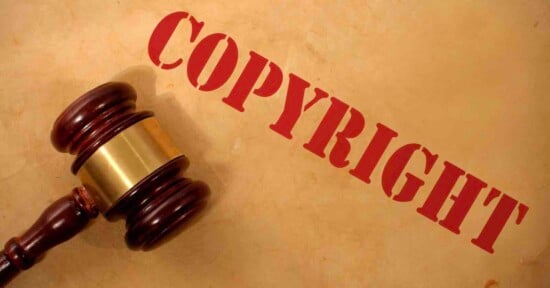A judge’s gavel rests on a brown surface, with the word "COPYRIGHT" in large red letters diagonally across the image.
