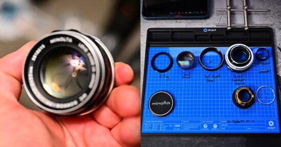 A person's hand holds a Minolta camera lens with reflective glass on the left. On the right, a blue mat displays disassembled lens parts, including rings and glass elements. The mat has labels and a Minolta lens cap.