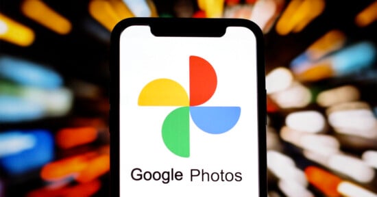 A smartphone displays the Google Photos logo and app name on its screen, with a colorful, blurred background of lights.