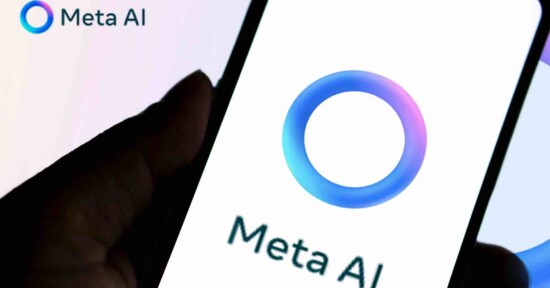 A hand holds a smartphone displaying the Meta AI logo, which features a blue and purple gradient circle, with the text "Meta AI" below it. The same logo and text appear in the image's top left corner.