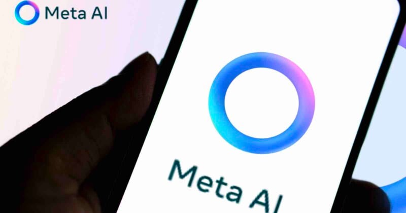 A hand holds a smartphone displaying the Meta AI logo, which features a blue and purple gradient circle, with the text "Meta AI" below it. The same logo and text appear in the image's top left corner.