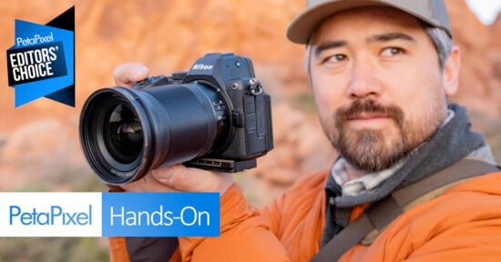 A man in an orange jacket holds a Nikon camera outdoors, looking slightly away. The image features "PetaPixel Hands-On" and "Editors' Choice" banners in the corners.