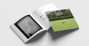 Two photography magazines are displayed on a white surface. One magazine is open, showing a black-and-white abstract photo, while the other is closed, showing a green lawn with a person lying down and the title "Bibi Photography Magazine.