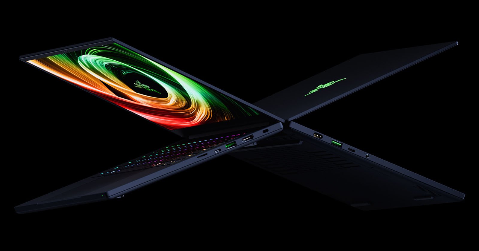 Two sleek black gaming laptops positioned back-to-back in an "X" shape, with colorful displays and illuminated keyboards, set against a solid black background.