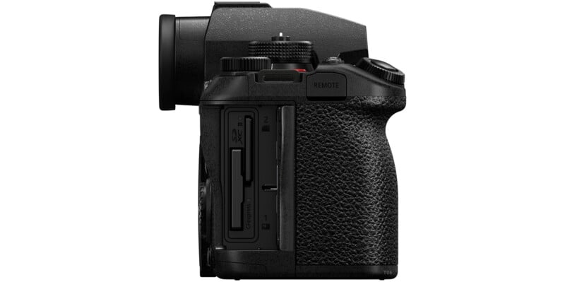 Side view of a black digital camera with textured grip, showing open memory card slots labeled 1 and 2, and a button labeled "REMOTE" above the slots.