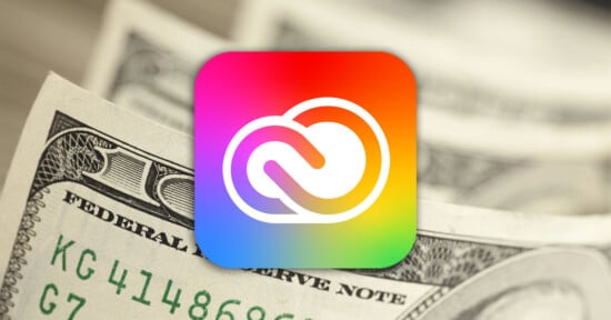A colorful Adobe Creative Cloud logo is centered over a close-up of U.S. $100 bills, suggesting themes of cost or value related to Adobe's subscription services.