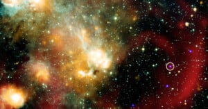 A colorful image of deep space showing bright stars, glowing gas clouds in orange and green hues, and a purple circled object among scattered stars on a dark background.
