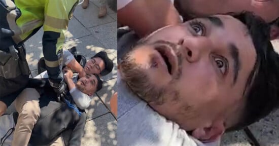 A close-up of a distressed man lying on the ground, being restrained by a uniformed officer, with another man beside him. The man's facial expression shows fear and shock.