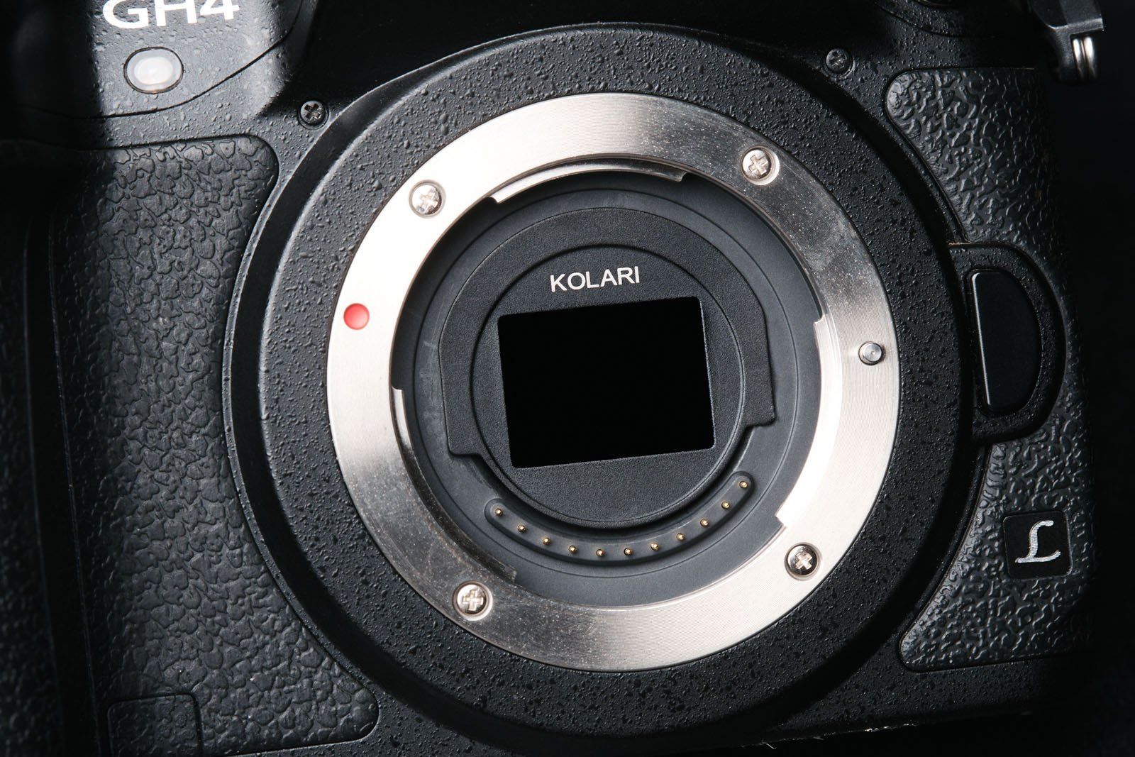 Close-up of a Panasonic GH4 camera body showing the lens mount with a Kolari infrared filter installed, highlighting the sensor area and surrounding metallic mount details.
