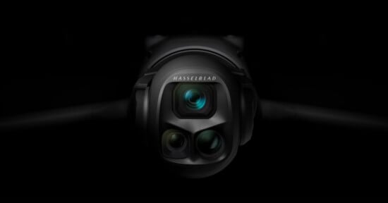 Close-up of a Hasselblad camera with three lenses, set against a dark background, highlighting the camera's sleek and modern design.