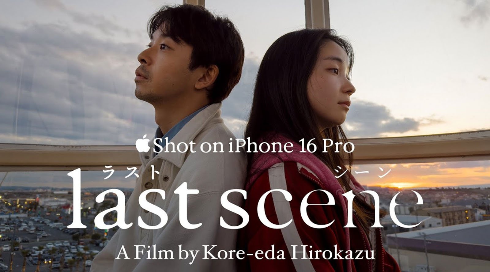 A man and woman sit back-to-back inside a glass enclosure overlooking a city at sunset. Text reads: “Shot on iPhone 16 Pro. last scene. A Film by Kore-eda Hirokazu.”.