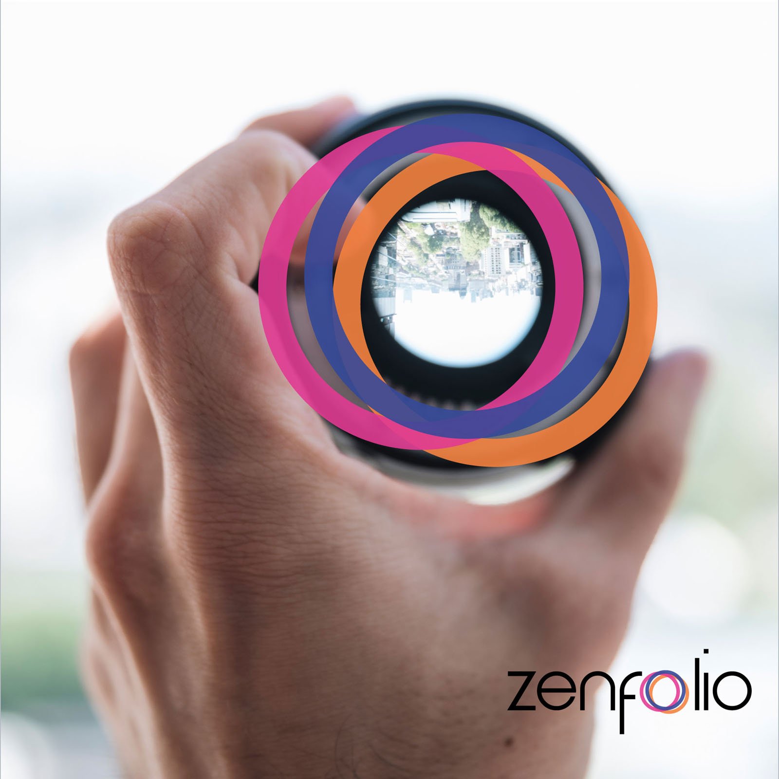 A hand holds a camera lens facing outward, with an upside-down image of a street visible through it. Overlapping colorful rings overlay the lens. The word "zenfolio" appears in the bottom right corner.