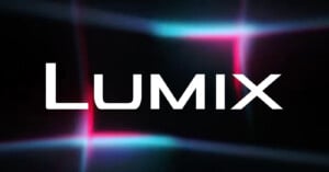 The image features the word "LUMIX" in bold white letters centered on a dark background with intersecting neon blue and pink light beams.