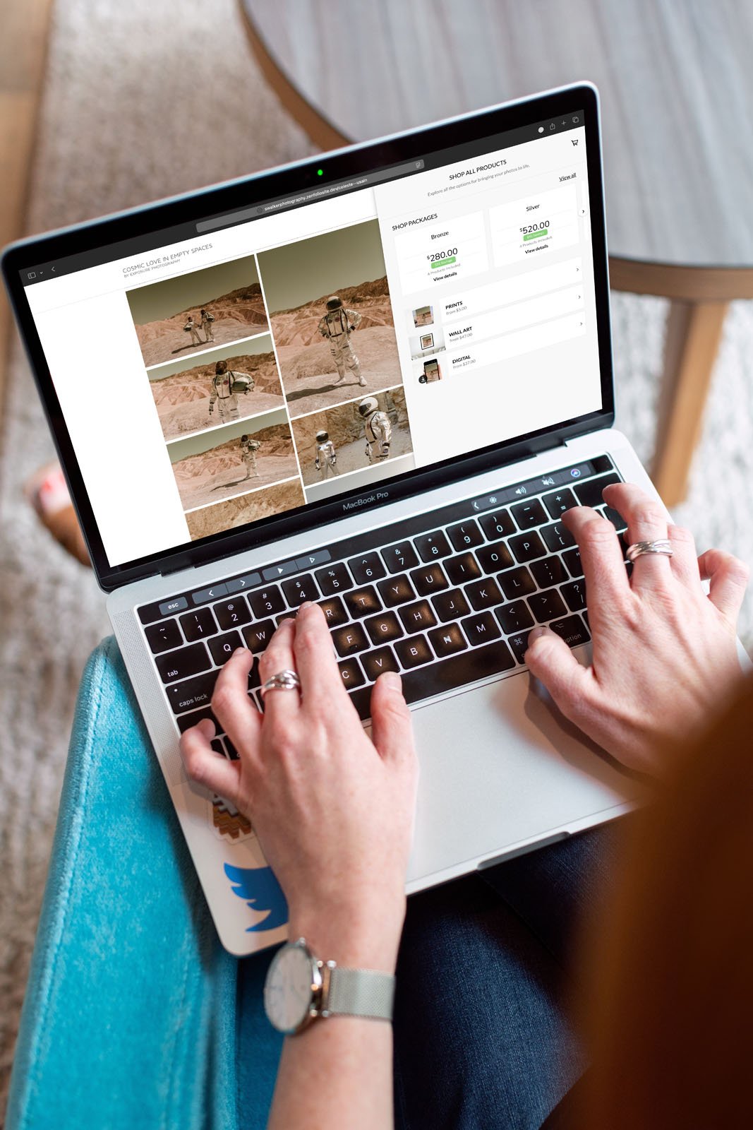 A person using a laptop views a website featuring Mars rover images, with options to select and order prints. Their hands rest on the keyboard, and the laptop sits on their lap near a wooden table.