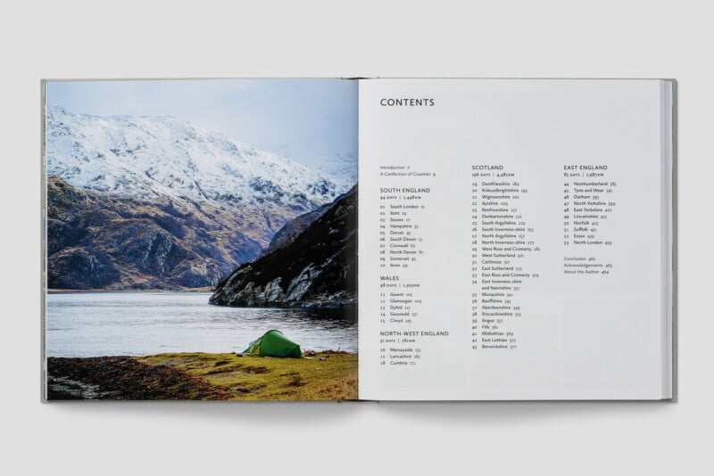 A book opened to a contents page on the right and a photo of a green tent pitched by a lake with snowy mountains in the background on the left. The contents list regions of England, Wales, and Scotland.