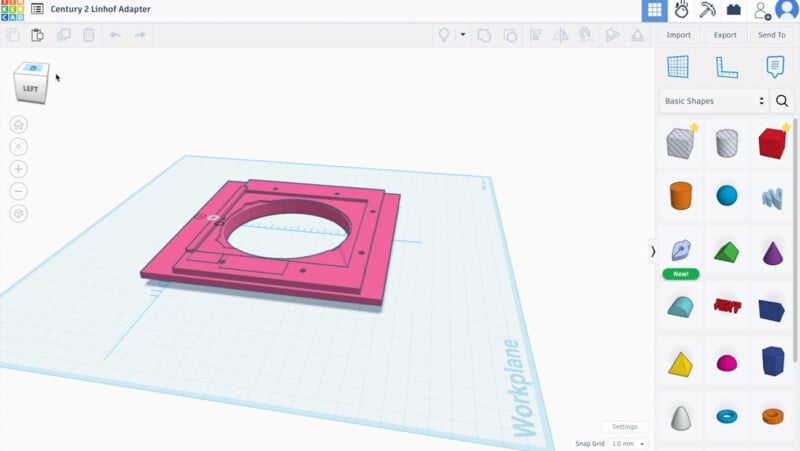 Screenshot of a Tinkercad workspace showing a 3D model of a flat, square pink adapter with a large circular cutout in the center, placed on a grid workplane, with basic shapes menu on the right.