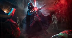 Darth Vader wields a red lightsaber in a dramatic, smoky scene with stormtroopers and other figures in the background, illuminated by red and blue lighting.