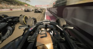 Onboard view from a black and gold Formula 1 car racing alongside several other cars on a track, with "Qatar Airways" banner visible above. The scene captures high speed and intense competition.