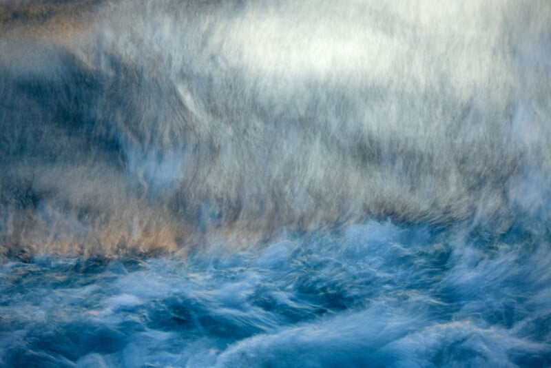 Abstract image of swirling blue and white colors resembling turbulent ocean waves, with soft, blurred textures creating a sense of movement and dynamic energy.