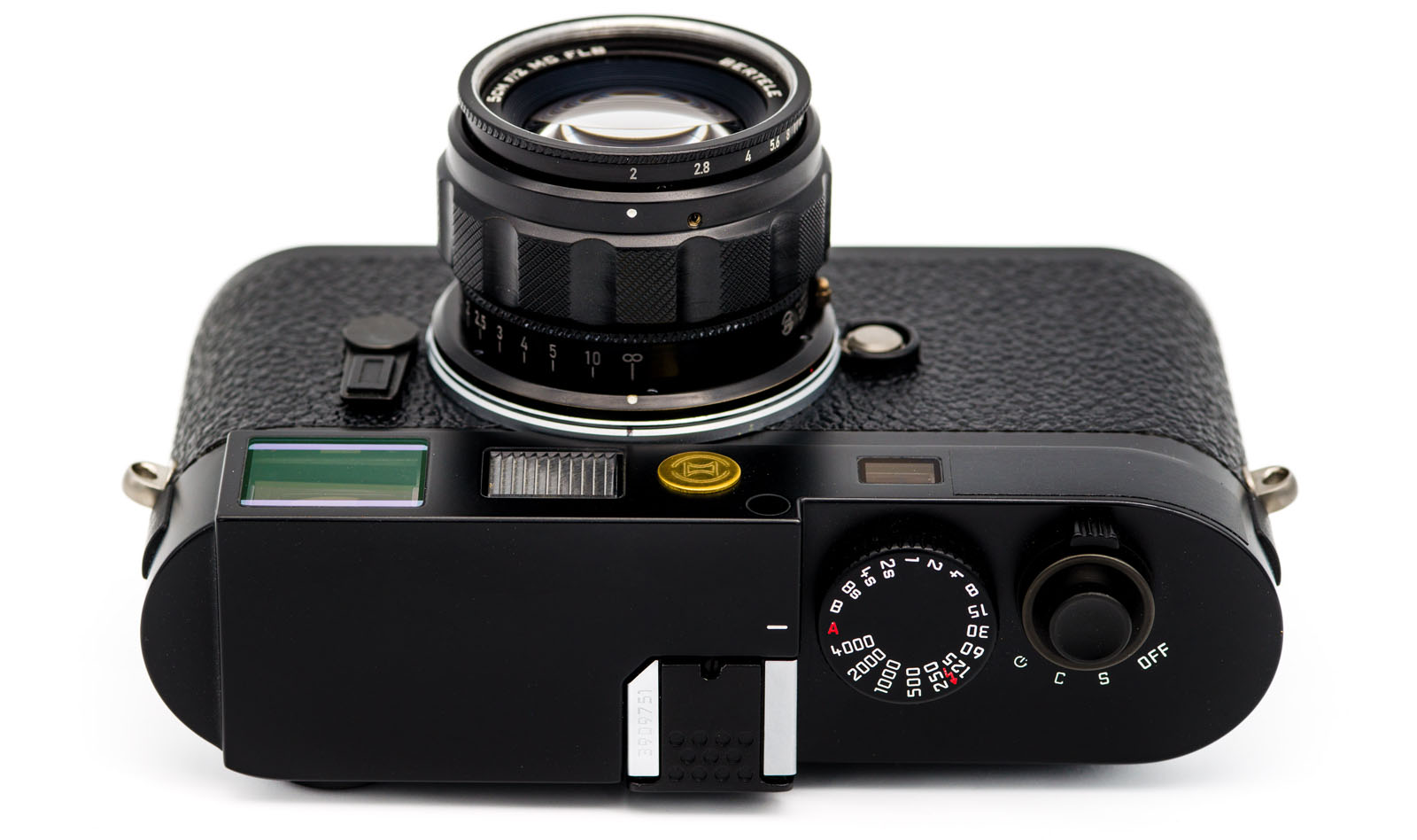 A black vintage film camera viewed from above, showing the lens, shutter speed dial, viewfinder, and textured grip. The camera is set against a white background.